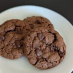 Chocolate brown cookies with a crinkled top dotted with chocolate chips.